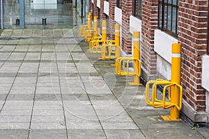 A row of bright yellow bicycle parking points