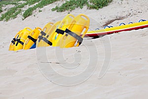 Row of bright yellow floatation devices on beach