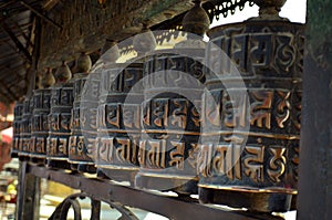 Row of buddhist prayer drums wheels rolls in Swayambhu Swayambhunath Temple