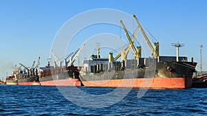 A row of bulk carrier ships in port