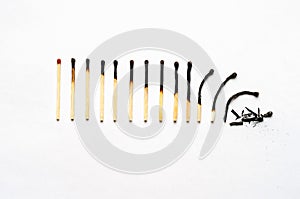 Row of burned-out matches over the white background