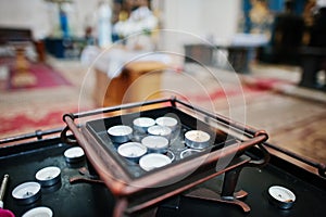 Row of burning circle candles on a stand at church