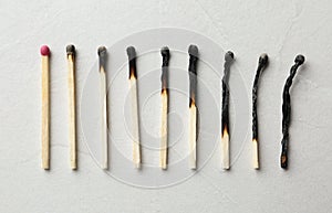 Row of burnt matches and whole one on light backgroundncept