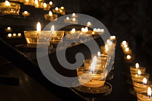 Row of candles in a church a symbol of religion and a memory of beloved ones