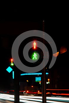 a row of cars drive past a traffic light with green and red colors, illuminated in the night sky