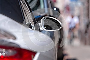 Row of cars parked on the street side, white sports car in the foreground, closeup of details