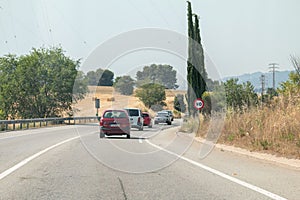Row of ccars driving down a highway under the bright sunlight