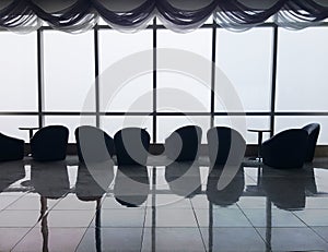 Row of chairs in executive office waiting room. background outdoor modern lobby big window and blue sky with clouds.