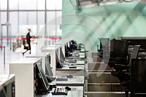 Row of check-in desks with computer monitors at empty airport terminal due to coronavirus pandemic/Covid-19 outbreak