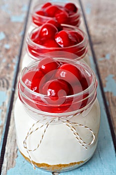 Row of cherry cheesecakes in mason jars