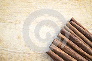 Row of cinnamon sticks aside on a wooden background