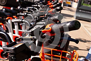 Row of city parked bicycles bikes for rent on sidewalk in