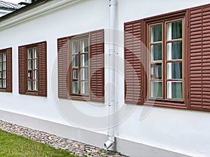 Row of classical wooden windows with shutters on white facade wall
