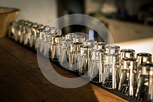 Row of clean shiny glasses lined up on bar counter