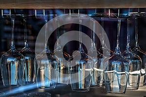 Row of clean wine glass  hanging on stand upside down in shop window. Lots of wine glasses dry on dryer