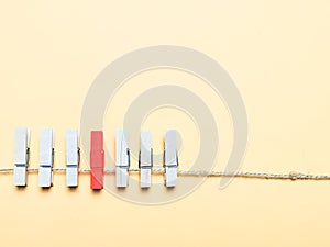 A row of clothes peg with single red color. Concept of individuality and virus infected.