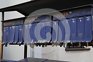 Row of cluster mailboxes with numbered compartments and locks on the sidewalk