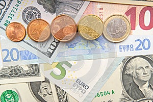 Row of coins on background of various Euro and Dollar banknotes