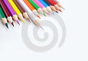 A row of colored pencils on white background with selected focus