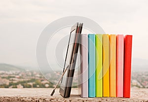 Row of colorful books with electronic book reader