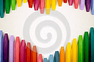 Row of colorful crayon over stripe pattern paper