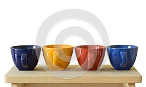 Row of colorful cups on wooden table