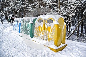 A row of colorful dustbins for waste segregation .