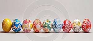 Row of colorful hand painted Easter eggs on a light grey background. Easter decoration, banner, panorama, background