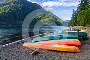 Row of colorful kayaks lying on the shore of Lake Crescent