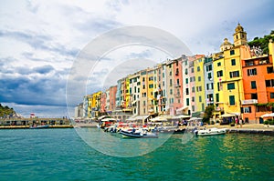 Row of colorful multicolored buildings houses of Portovenere coastal town village and boats in harbor of Ligurian sea, Riviera di