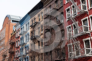 Row of Colorful Old Apartment Buildings in Greenwich Village of New York City with Fire Escapes