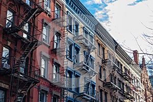 Row of Colorful Old Brick Apartment Buildings in Greenwich Village of New York City with Fire Escapes