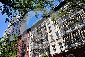 Row of Colorful Old Buildings with Fire Escapes on the Upper East Side of New York City with Green Trees