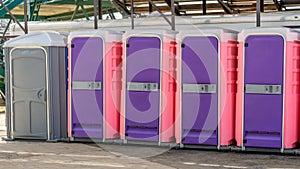 Row of colorful plastic portable restrooms