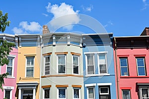 row of colorful townhouses with blue sky