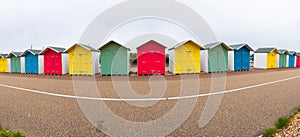 A row of colorful wooden beach huts on the beach in Eastbourne