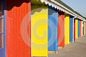 A row of colourful beach huts.