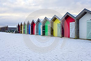 A row of colourful beach huts in the winter