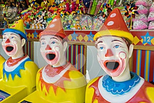 Row of colourful clowns at funfair