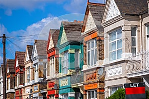 A row of colourful terraced houses in London with with a LET sign photo