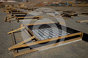 Row of concrete foundation formworks at construction site