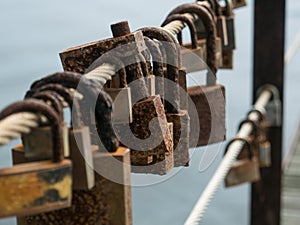 Row of corroded, rusty love locks / padlocks attached to bridge in Portugal.