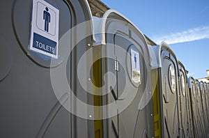 Row of dark grey portable toilets