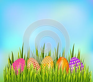 Row of decorated Easter eggs hiding in grass on sky background. Bottom border element.