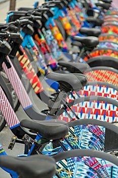 Row of decorative bikes for electric transportation in downtown urban city for traveling or moving around