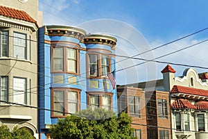 Row of decorative colorful houses with visible powerlines and modern home facades in San Francisco California