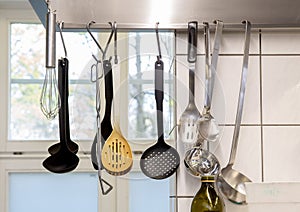 Row of decorative spats suspended from the ceiling in a kitchen setting. photo