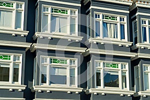 Row of decorative windows on condo or appartment building in the downtown city with blue color and white accent paint