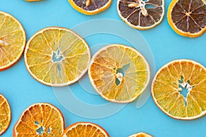 Row of dehydrated citrus fruits as lemons, tangerines, oranges on blue background.
