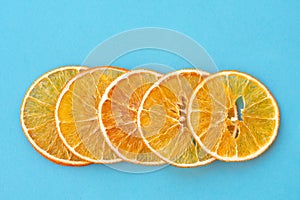 Row of dehydrated citrus fruits as oranges on blue background
